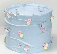 a blue cake with flowers and butterflies on it's top is featured in this post