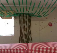 a red and white checkered table cloth with green strips on it in front of a window