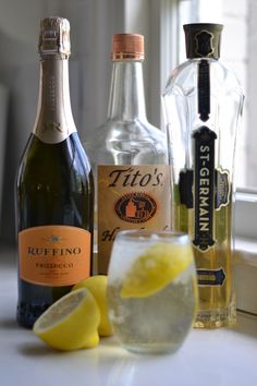 bottles and glasses filled with alcohol sitting on a counter