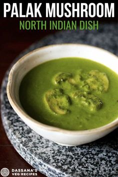 a bowl filled with green soup on top of a table