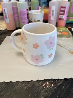 a coffee cup sitting on top of a table next to other cups and containers filled with liquid