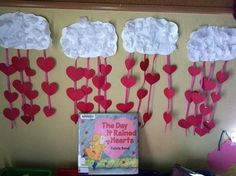 some paper hearts hanging from the side of a wall next to a book and other items