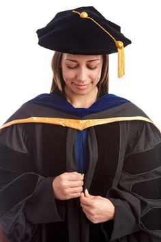 a woman wearing a graduation gown and holding a book