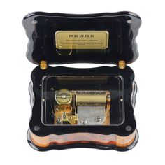 an antique musical box that is black and gold