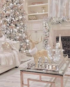 a white christmas tree in a living room next to a fire place and other decorations