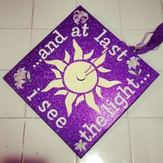 a purple and white graduation cap with the words land at last, see the light on it