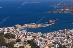 an aerial view of a city with water and buildings in the foreground, on which there is a large cargo ship docked