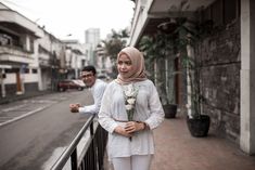 two people standing next to each other on a street