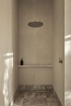 an empty bathroom with white walls and tile flooring