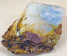 a piece of rock sitting on top of a white table next to a blue and yellow object