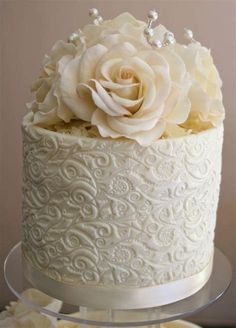 a white wedding cake decorated with flowers and pearls