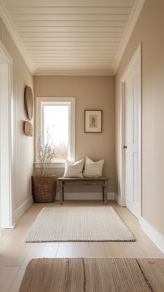 an empty room with a bench, rug and window