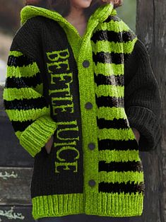 a woman wearing a green and black striped knitted cardigan with words written on it