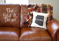 two pillows sitting on top of a brown couch next to a pillow that says the fold's throw