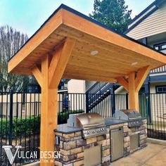 an outdoor covered grill area in front of a house