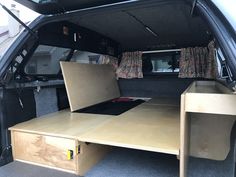 the back end of a van with an open trunk and desk in the cargo area