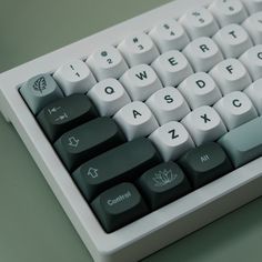 a close up view of a keyboard with white keys and green letters on it's side