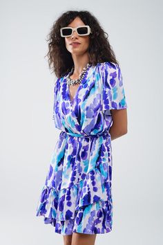 Introducing our Wrap Short Dress in Blue and Purple Tie-Dye, a vibrant and stylish addition to your summer wardrobe. This lovely short dress features a super flattering wrap design with a matching belt, creating a tailored fit that accentuates your waist. The ruffle at the hem adds a playful touch, while the eye-catching blue and purple tie-dye pattern ensures you stand out in any crowd.  Crafted from 100% Polyester, the dress offers a lightweight and comfortable wear, perfect for warm weather. Short Wrap Dress, Wrap Dress Short, Wrap Shorts, Dress With Short Sleeves, Purple Tie Dye, Scarf Headband, Medium Purple, Tie Dye Dress, Dyed Dress