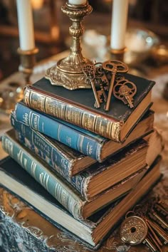 a stack of books sitting on top of a table next to a candle and some keys