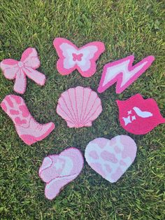 pink and white crocheted beach toys laid out in the grass on top of green grass