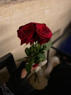 a woman holding a bouquet of red roses