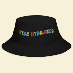 Keep the festival spirit alive with our "Stay Hydrated" Bucket Hat. This hat isn't just an accessory; it's a reminder to take care of yourself and spread positive vibes while you groove to the beats of EDM, Rave, and your favorite music festivals. 🎵 Key Features 🎵 Premium quality fabric for all-day comfort Unique design that promotes staying hydrated and positive vibes Trendy bucket hat style that adds flair to your festival attire One size fits most for convenient wear 🌈 Festival Vibes 🌈 Wh Affordable Cap For Music Festival, Adjustable Black Bucket Hat With Letter Print, Fun Adjustable Hats For Streetwear, Fun Adjustable Streetwear Hats, Retro Black Adjustable Bucket Hat, Adjustable Fun Hat For Streetwear, Retro Adjustable Black Bucket Hat, Casual Black Bucket Hat For Festivals, Trendy Adjustable Hats For Music Festival