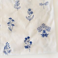 the blue flowers are embroidered onto the white fabric