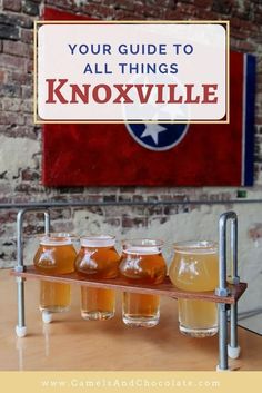 a sign that says your guide to all things knoxsville with honey jars in front of it