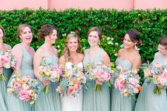 a group of women standing next to each other with bouquets in front of them