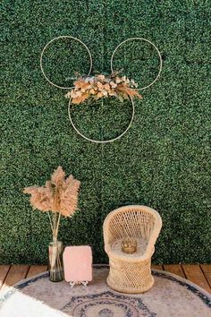 a rattan chair sits in front of a green wall with an iron mickey mouse head on it