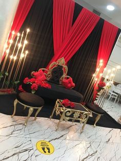 an elaborately decorated room with red drapes and gold chairs in front of it