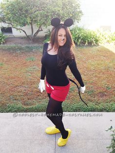 a woman in mickey mouse costume posing for the camera with her hand on her hip