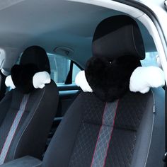 the interior of a car with two black and white plush animal headrests on