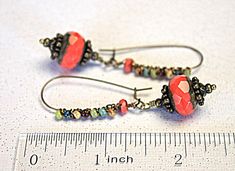 Gorgeous, chunky Coral red Czech glass beads sway from long brass kidney ear wires, wrapped with colorful little glass beads...Unique & Charmingly Bohemian! Uniquely hand crafted with these quality materials: ~ Hand carved, faceted Czech glass beads with a rustic Picasso finish ~ Czech glass multi-colored Picasso finish seed beads ~ Antiqued brass findings and lead & nickel-free long kidney style ear wires Measuring 2-1/4 inches from the top of the ear wires to the bottom of the beads, t Red Czech Glass Beaded Earrings With Dangling Beads, Adjustable Red Czech Glass Beaded Earrings, Red Faceted Beads Jewelry For Crafting, Red Bohemian Earrings With Large Beads, Earthy Bohemian, Bead Drop Earrings, Beaded Drop Earrings, Coral Red, Earrings Long