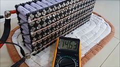 a pile of batteries sitting on top of a table next to an electronic thermometer