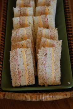 several sandwiches are arranged on a green plate