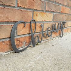 a metal name sign on the side of a brick wall that says cheesy