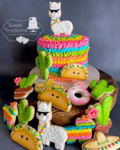 there are many decorated cookies in the shape of animals and llamas on this cake