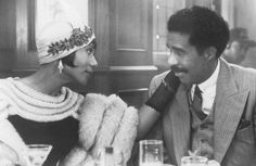 a man and woman sitting at a table talking