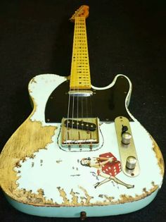 an old, worn out electric guitar with some knobs on it's neck