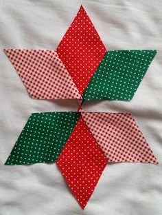 two red and green pieces of fabric on top of each other in the shape of an origami star