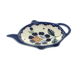 a small blue and white bowl with flowers on the bottom, sitting in front of a white background