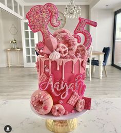 a birthday cake with pink icing and decorations