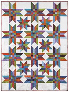 a quilt made with different colored blocks and strips on it's sides, including the center