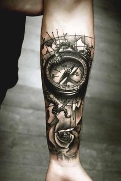 a man's arm with a compass and rose tattoo on the left side of his leg