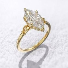 a yellow gold ring with two pear shaped diamonds