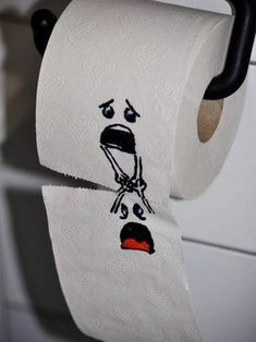 two rolls of toilet paper with faces drawn on them, hanging from a black handle