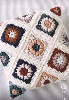 a crocheted pillow with flowers on it