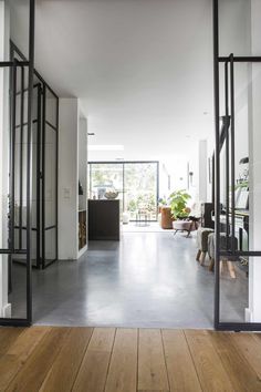 an open living room with wooden floors and glass doors