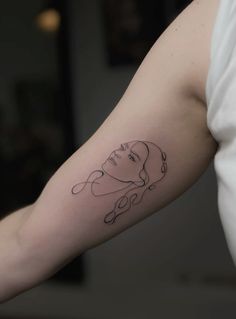 a woman's arm with a black and white line work tattoo on her left arm